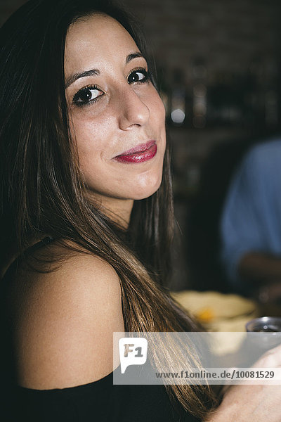 Close up of Hispanic woman drinking in nightclub