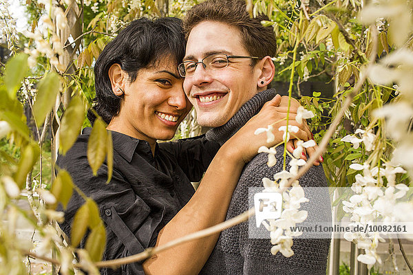 Smiling couple hugging in foliage
