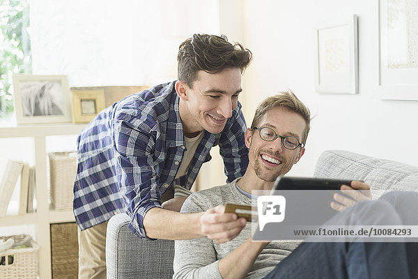 Caucasian gay couple shopping online on digital tablet
