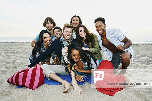 Smiling friends posing on beach