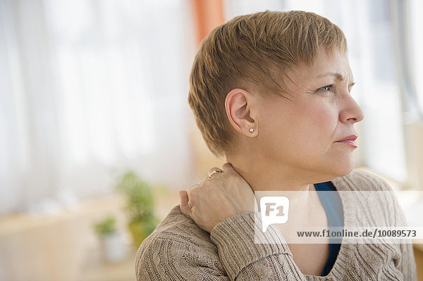 Anxious Caucasian woman rubbing her neck