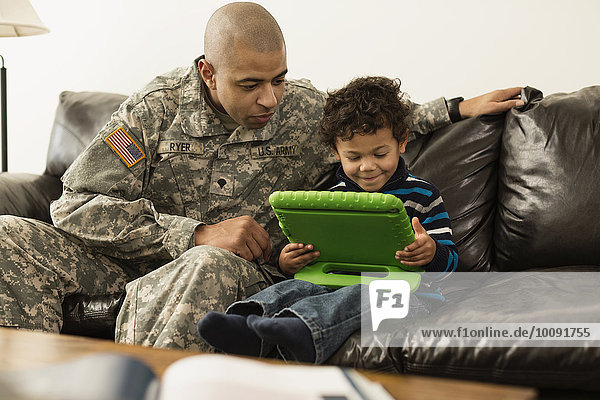 benutzen Couch Menschlicher Vater Sohn Soldat mischen Tablet PC Mixed