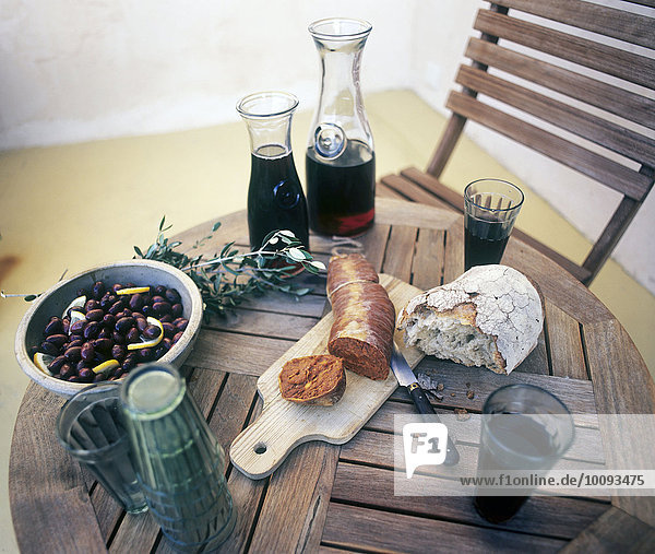 Holztisch Brot Wurst Wein Salat Bohne