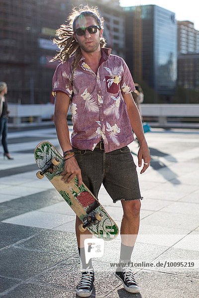 Young man holding skateboard  portrait