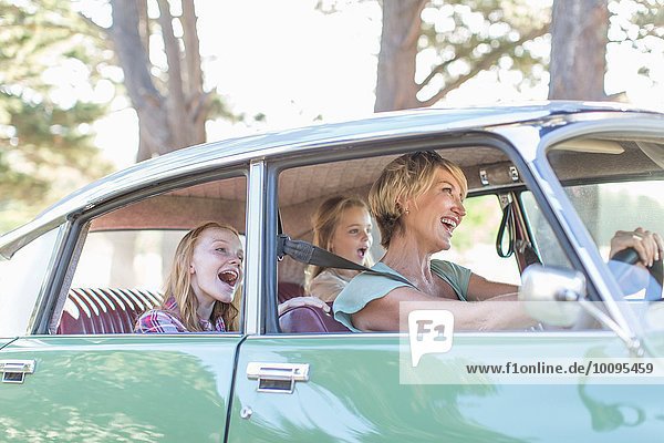 Großmutter fährt Auto  Enkelinnen sitzen auf dem Rücksitz