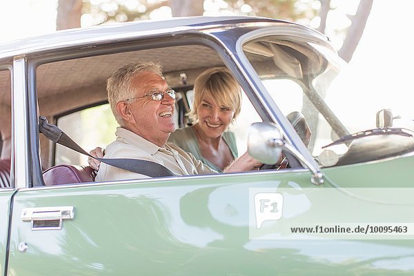 Senior man and mature woman in car together  smiling
