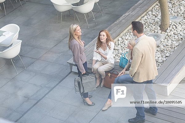 High angle view of businessman and women chatting on hotel terrace