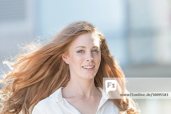 Porträt einer schönen jungen Frau mit langen roten Haaren