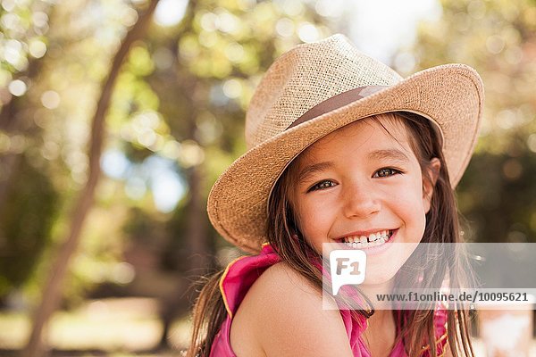 Porträt des süßen lächelnden Mädchens mit Strohhut