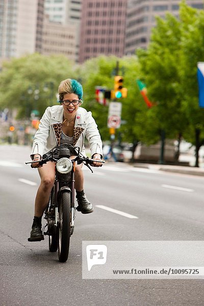 Porträt einer jungen Frau mit bunten Haaren  Motorradfahren