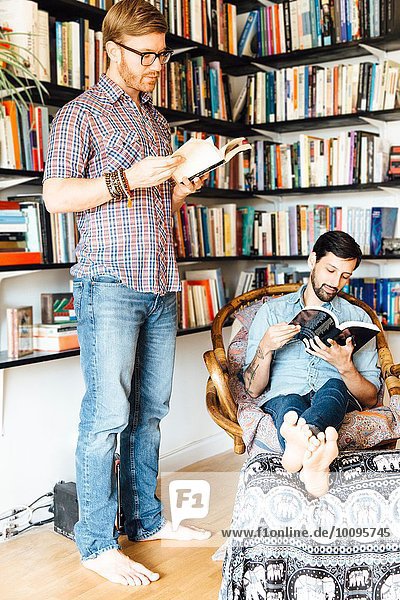 Männliches Paar zu Hause  lesend