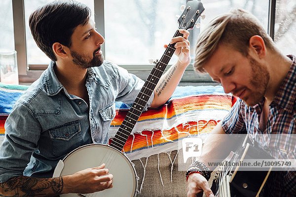 Männliches Paar zu Hause  Gitarre und Banjo spielen