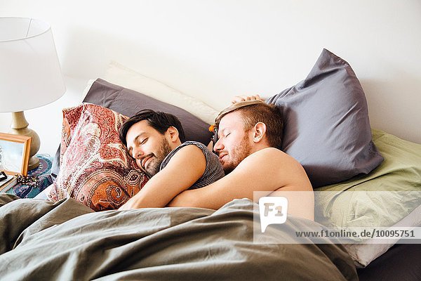 Männliches Paar im Bett  schlafend umarmend
