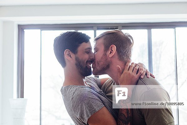 Männliches Paar zu Hause  herumalbern  küssen und lachen