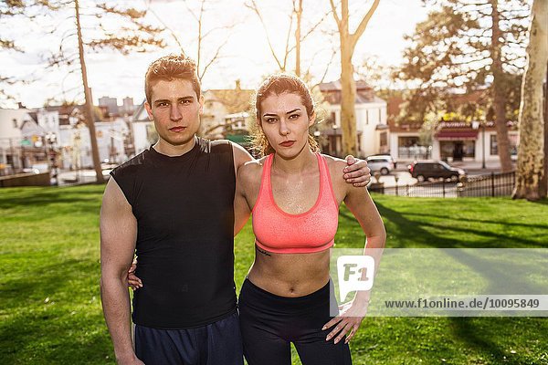 Portrait of confident young sport couple in park