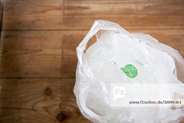 Recycelbare Einkaufstaschen aus Kunststoff auf Holzboden