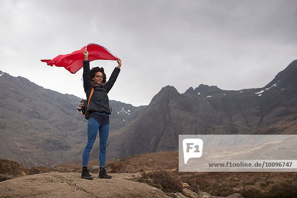 Frau mit roter Flagge in den Bergen  Fairy Pools  Isle of Skye  Hebrides  Schottland