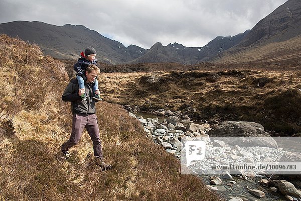 Father and son hiking  Fairy Pools  Isle of Skye  Hebrides  Scotland