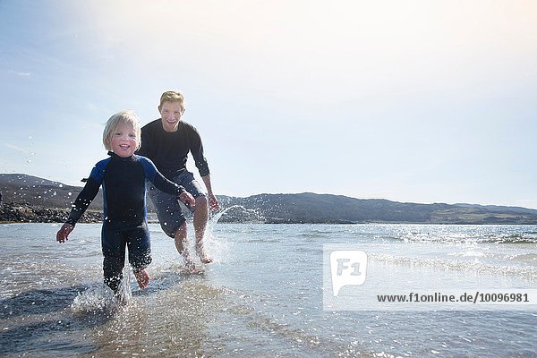 Vater und Sohn laufen am Strand  Loch Eishort  Isle of Skye  Hebrides  Schottland