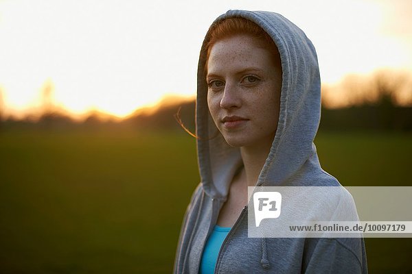 Portrait of woman with hood up after exercising in the park