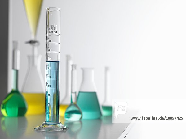 Laborglas auf Labortisch mit Messzylinder im Vordergrund