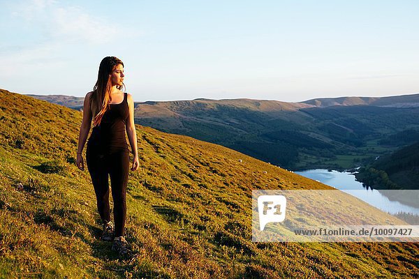 Young woman strolling  Talybont Reservoir in Glyn Collwn valley  Brecon Beacons  Powys  Wales