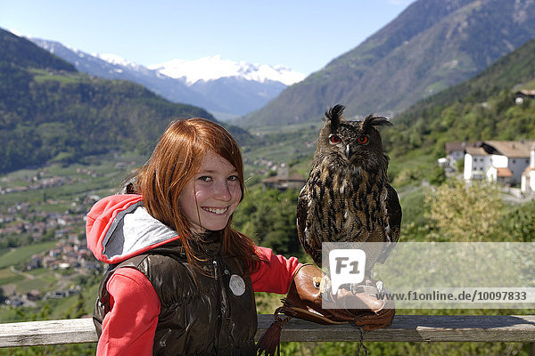 Mädchen mit Uhu (Bubo bubo) auf dem Arm  Greifvogelflugschau am Schloss Tirol  Dorf Tirol  Burggrafenamt  Südtirol  Italien  Europa