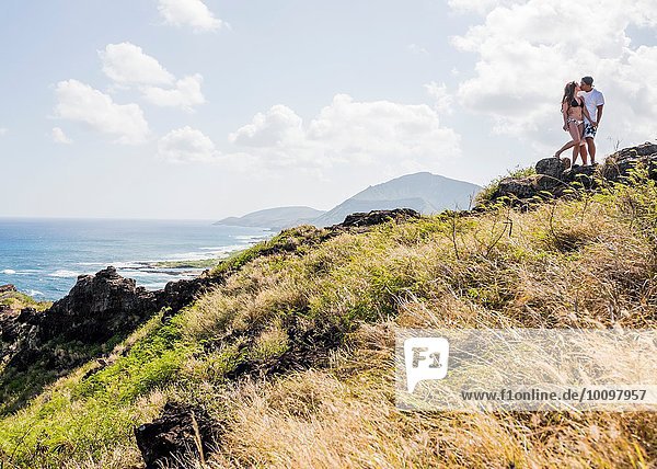 Young couple kissing on cliff top on Makapuu coast path  Oahu  Hawaii  USA