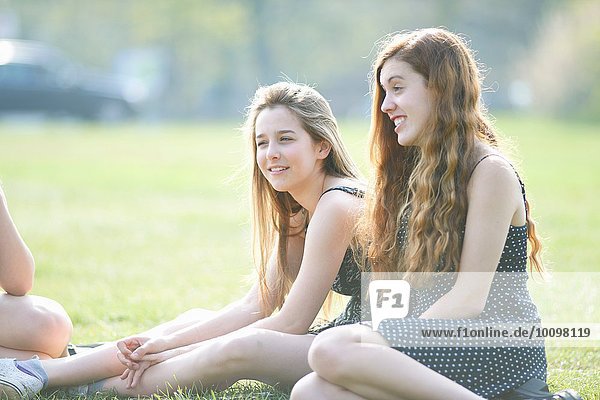 Teenager-Mädchen sitzen im Park und plaudern.
