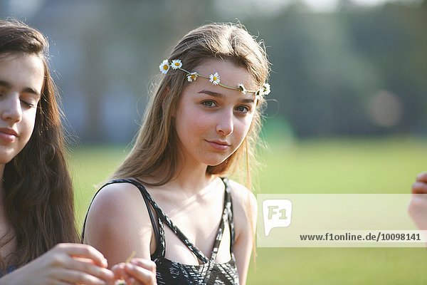 Porträt eines Teenagermädchens mit Gänseblümchen-Kopfschmuck im Park