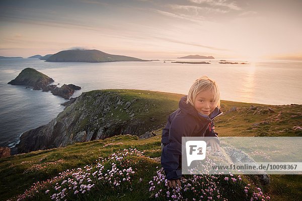 Young boy sitting on hillside  Slea head  County Kerry  Ireland