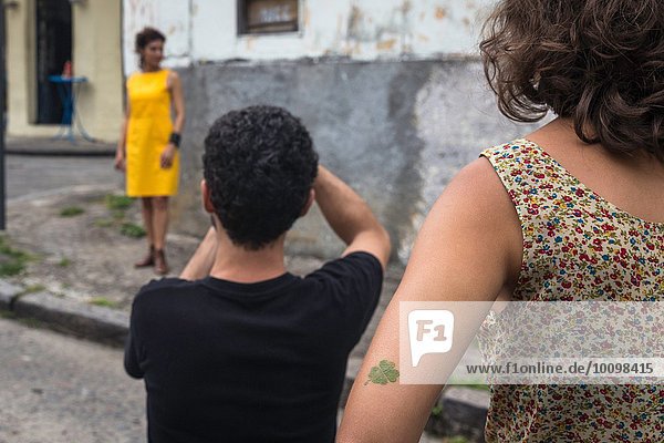Behind the scenes of an urban fashion shoot with female model and male photographer
