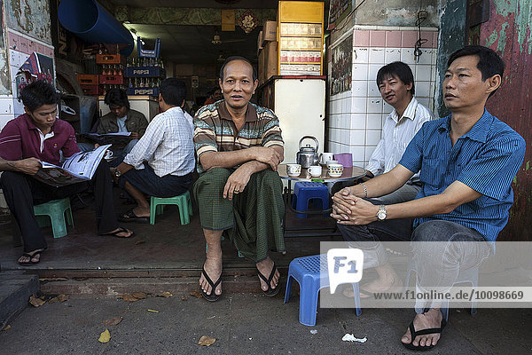 Local men drinking coffee in front of a small cafe  Yangon  Myanmar  Asia
