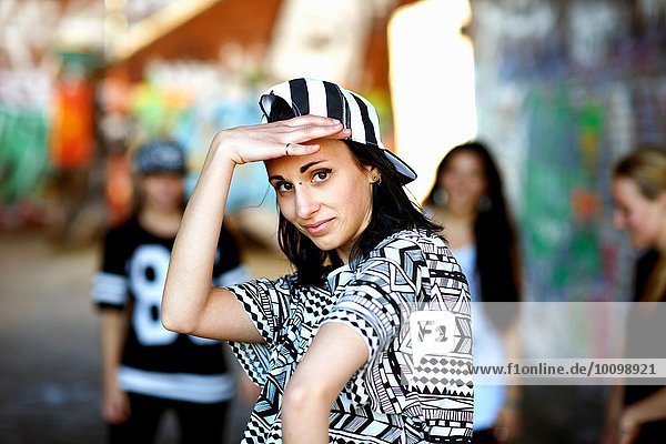 Young woman wearing baseball cap backwards  looking at camera