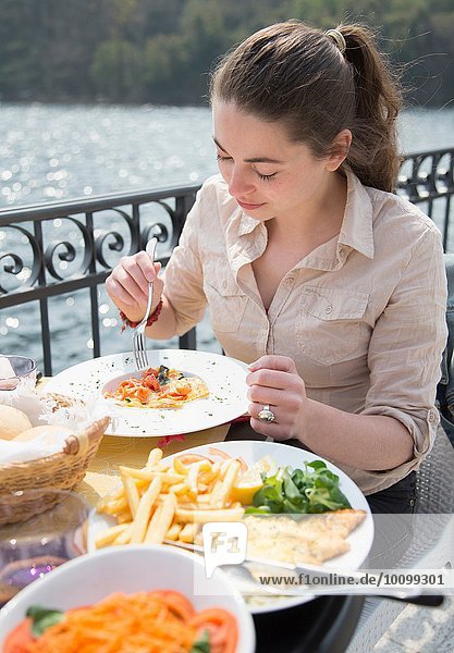 Junge Frau beim Mittagessen im Restaurant am See  Mergozzo-See  Verbania  Piemonte  Italien