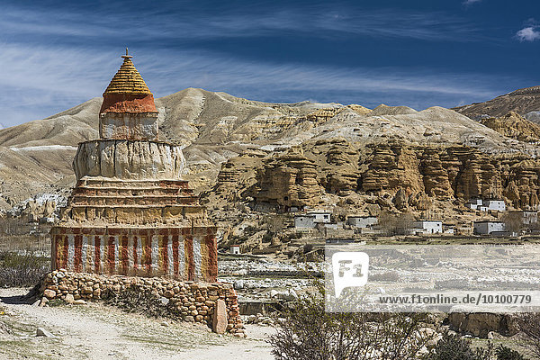 Bunt bemalter buddhistischer Stupa  Tschörten  vor Berglandschaft  hinten Erosionslandschaft und Wohnhäuser von Garphu  Chhosar  Oberes Mustang  ehemaliges Königreich Mustang  Nepal  Asien