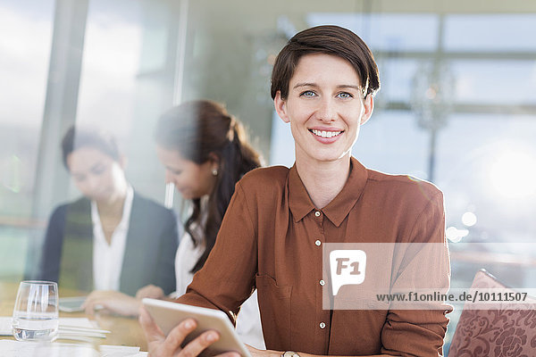 Portrait smiling businesswoman with digital tablet in office