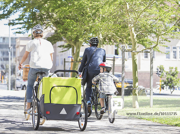 Familien auf dem Fahrrad im sonnigen Stadtpark