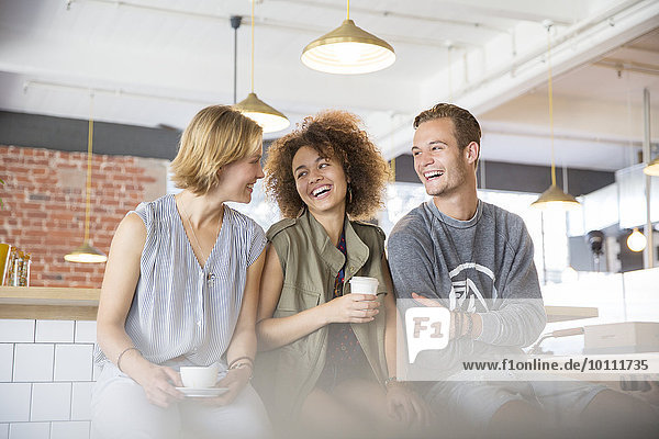 Lachende Freunde beim Kaffeetrinken im Cafe