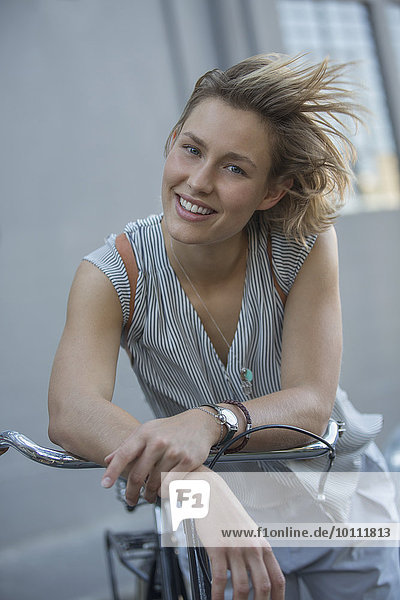 Portrait lächelnde blonde Frau auf dem Fahrrad
