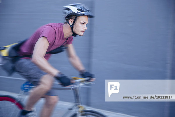 Fokussierter Fahrradkurier mit Helm unterwegs
