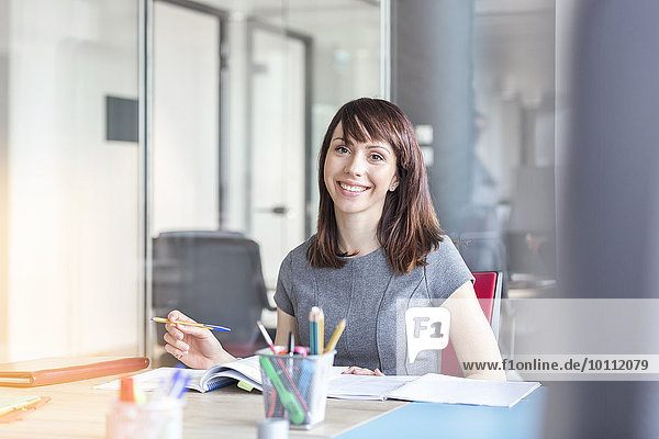 Portrait confident brunette businesswoman working in conference room
