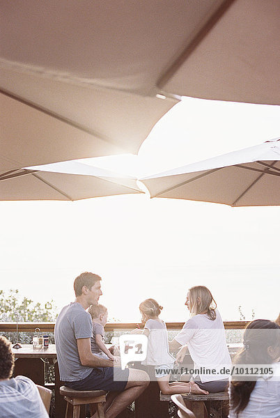 sitzend Sohn unterhalb Restaurant Sonnenschirm Schirm Tochter