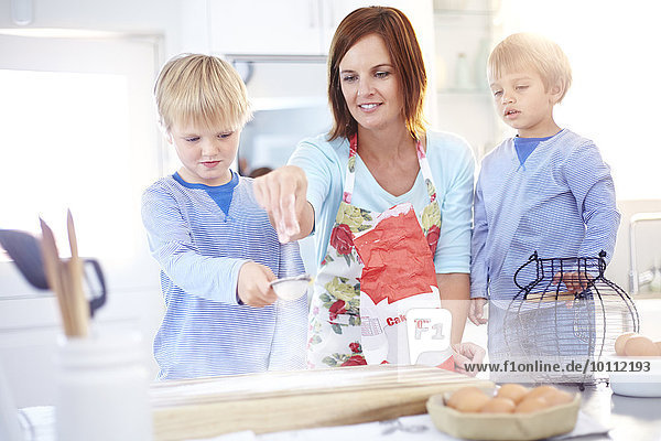 Mutter und Söhne beim Backen in der Küche