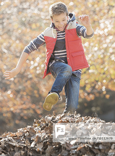 Haufen Begeisterung Junge - Person über springen Laub