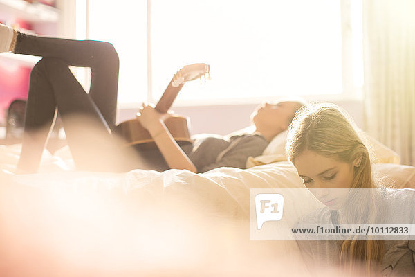 Jugendlicher Schlafzimmer Gitarre abhängen Sonnenlicht Mädchen spielen