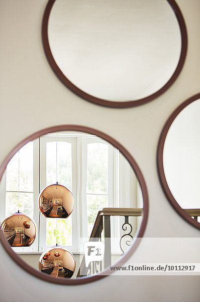 Reflektion von Kupferpendelleuchten im runden Spiegel