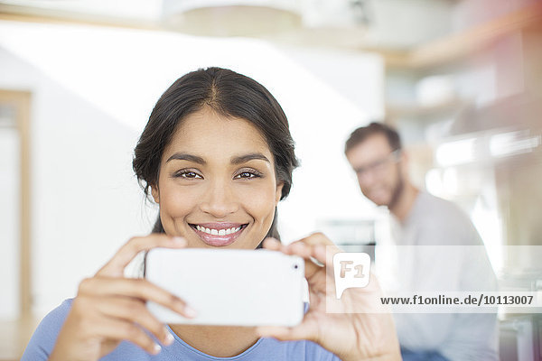 Portrait smiling woman using camera phone