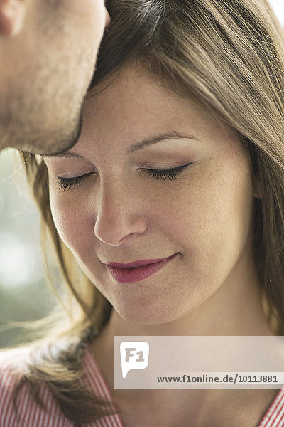 Man kissing woman's forehead  cropped
