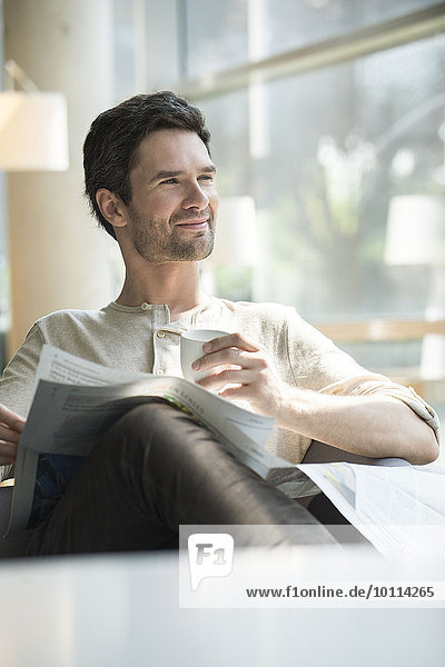 Mann entspannt sich bei Kaffee und Zeitung